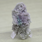 Calcédoine botryoïde violette à tâches vertes et jaunies sur présentoir 52g