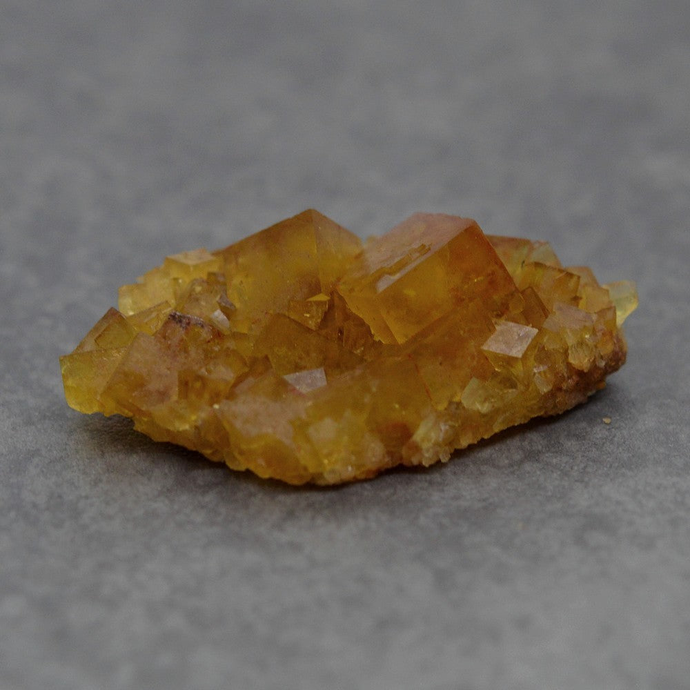 Druse de fluorite jaune miel foncée du Maroc 27g