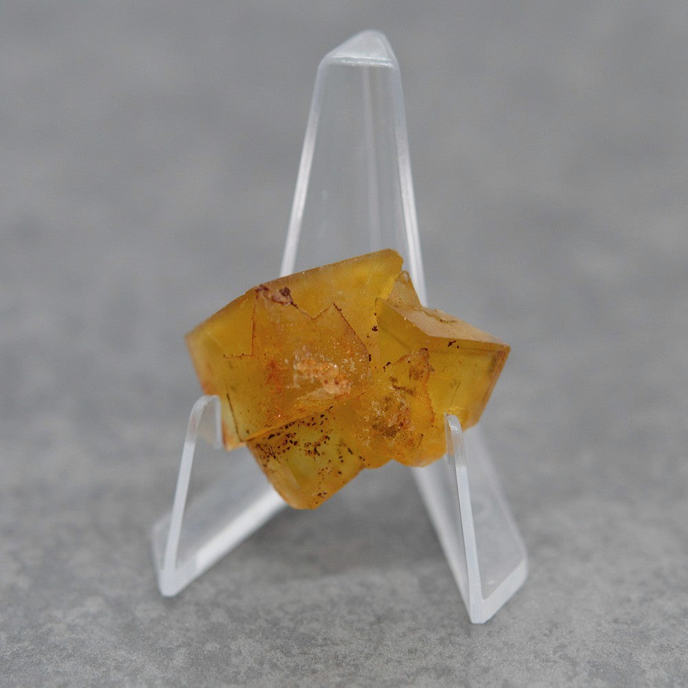 Pierre brute fluorite jaune miel foncée de 17g sur présentoir